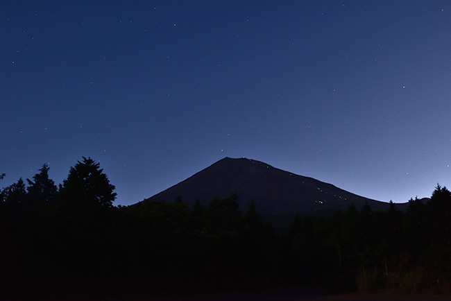 登山者のヘッドライトと星空